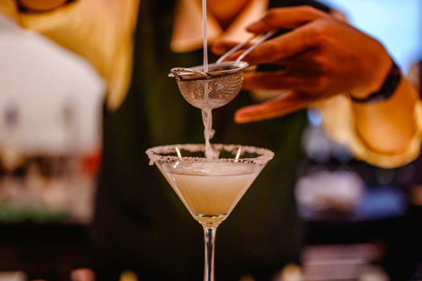 Bartender straining a cocktail